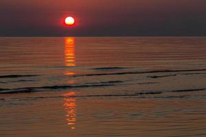 couleurs du coucher du soleil dans l'eau de mer photo