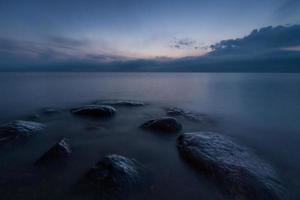 pierres sur la côte de la mer baltique au coucher du soleil photo