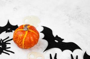 gros plan de mini pimpkin sur la table avec des chauves-souris feutrées et des araignées à proximité. concept de célébration d'halloween. mise au point sélective. photo