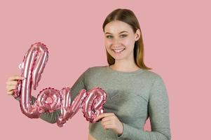 jeune femme tenant pointant vers le ballon d'amour. concept de la saint-valentin photo