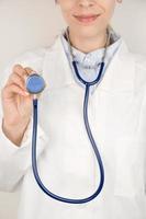 bannière verticale avec une femme médecin tenant le disque d'un stéthoscope vers la caméra se préparant à écouter le rythme cardiaque et les poumons d'un patient. concept de maladies respiratoires photo