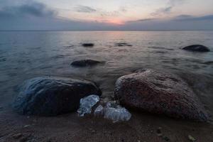 pierres sur la côte de la mer baltique au coucher du soleil photo