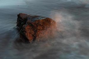 pierres sur la côte de la mer baltique au coucher du soleil photo