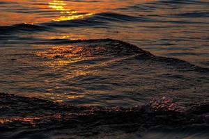 couleurs du coucher du soleil dans l'eau de mer photo