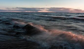 pierres sur la côte de la mer baltique au coucher du soleil photo