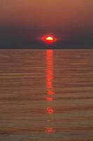 couleurs du coucher du soleil dans l'eau de mer photo