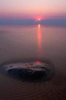 pierres sur la côte de la mer baltique au coucher du soleil photo