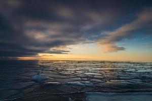 côte de la mer baltique avec galets et glace au coucher du soleil photo