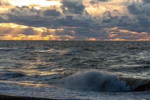 côte de la mer baltique avec galets et glace au coucher du soleil photo