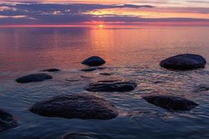 pierres sur la côte de la mer baltique au coucher du soleil photo