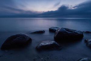 pierres sur la côte de la mer baltique au coucher du soleil photo