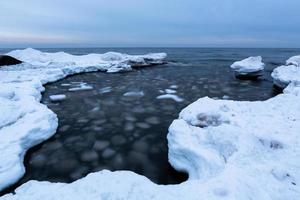 côte de la mer baltique en hiver avec de la glace au coucher du soleil photo