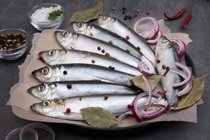 plusieurs harengs marinés aux épices sur papier parchemin photo