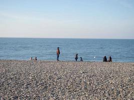 les gens sur la plage de galets de printemps. vacances à la plage. détente en mer. bord de mer rocheux. photo