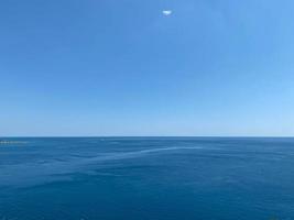 panorama d'un paysage marin avec des nuages blancs et l'eau bleue calme photo