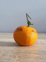 c'est une photo d'une petite orange sur une table en bois.