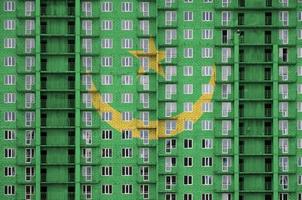 drapeau de la mauritanie représenté dans des couleurs de peinture sur un immeuble résidentiel à plusieurs étages en construction. bannière texturée sur fond de mur de brique photo