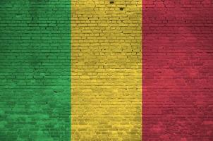 drapeau du mali représenté dans des couleurs de peinture sur un vieux mur de briques. bannière texturée sur fond de maçonnerie de gros mur de briques photo