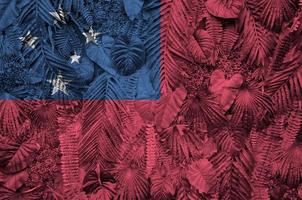 drapeau samoa représenté sur de nombreuses feuilles de palmiers monstera. toile de fond à la mode photo