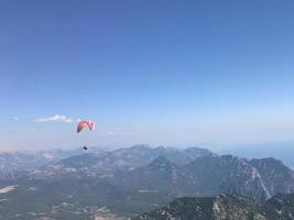 parachutiste avec un auvent bleu foncé sur le fond un ciel bleu au-dessus des nuages photo
