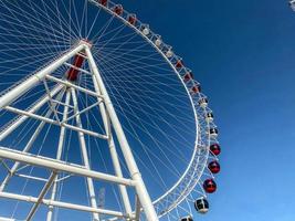 grande roue dans la ville contre le ciel bleu. carrousel pour l'équitation. attraction pour une visite guidée de la ville. grande, blanche, énorme grande roue photo