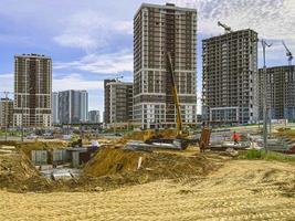 construction d'un nouveau complexe résidentiel dans le centre-ville. des maisons hautes en béton et en verre pour la vie des gens. construction d'immeubles de grande hauteur photo