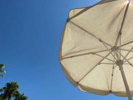 regardant un parasol contre un ciel bleu, par une chaude journée photo