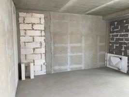 nouvel appartement, nouveau bâtiment sans finition ni réparation, avec planification libre et murs en béton, briques et blocs de silicate à gaz sans cloisons et avec de grandes fenêtres panoramiques photo