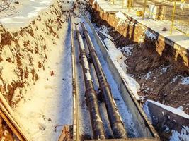 petits tuyaux noirs et étroits pour la pose de communications de plomberie. tuyaux en polypropylène sous la neige. travaux de rénovation dans un nouveau quartier résidentiel photo