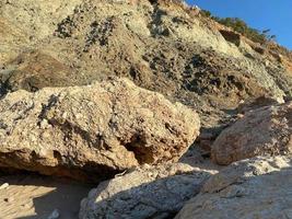 Grande roche de type dénoyautée de grès chamois au premier plan avec des cailloux de différentes couleurs et formes à l'arrière-plan photo