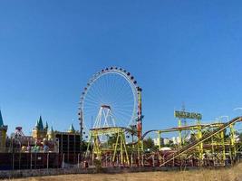 grande roue et montagnes russes au parc pier pacific au coucher du soleil avec des personnes faisant des attractions photo