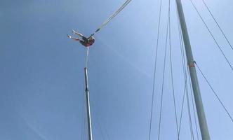 sauter sur une haute montagne. activités de plein air dans un pays chaud, saut à la corde, trampoline au bord des montagnes. une grande structure, une catapulte pour lancer les gens dans le ciel photo