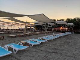 Chaises longues et parasol avec parasols sur la plage sur la mer en vacances dans un pays tropical de l'Est chaud touristique Southern Resort photo