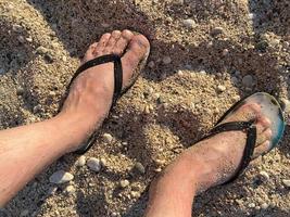 la section basse de l'homme se détend sur la plage de sable photo