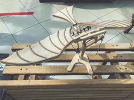 maquette d'avion en bois naturel. petit avion avec ailes et lattes de bois. jouet pour enfants, l'avion se dresse sur un piédestal photo