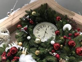 fond de noël avec des branches de sapin, des ballons colorés, une horloge photo