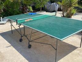 raquettes et balle sur table de ping-pong dans la cour de sport en plein air. concept de sport actif et d'entraînement physique photo