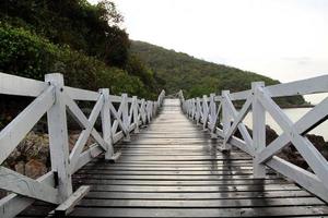le pont en bois près de la mer avec les montagnes en arrière-plan après la pluie. Pattaya, Thaïlande. photo