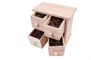 boîte en bois avec des cellules remplies de grains de café. Grains de café éparpillés côte à côte isolé sur fond blanc