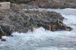 mer atteignant les rochers créant des éclaboussures d'écume photo