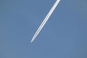 sillage blanc d'un avion sous le ciel bleu photo