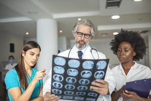 équipe de professionnels de la santé à la recherche d'une radiographie des poumons du patient. médecin masculin et féminin regardant la radiographie des poumons à l'hôpital pendant la pandémie de covid19 photo