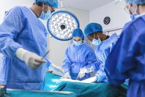 chirurgiens effectuant une opération en salle d'opération. chirurgie d'augmentation mammaire dans la salle d'opération implant d'outils de chirurgien. notion de soins médicaux. photo