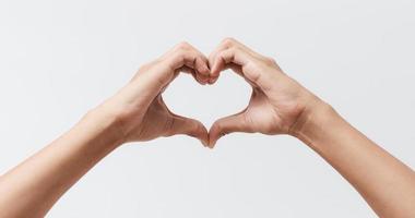 mains d'homme faisant une forme de coeur sur un fond blanc isolé photo