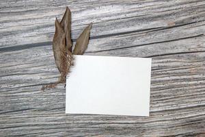 maquette de carte de voeux en papier a5 avec des feuilles sèches sur fond de bois photo