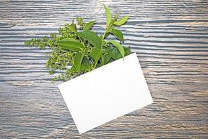 maquette de carte de voeux papier a5 avec des feuilles vertes sur fond de bois photo