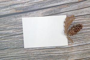 maquette de carte de voeux en papier a5 avec des feuilles sèches sur fond de bois photo