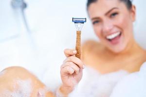 belle jeune femme brune prenant un bain dans la baignoire photo