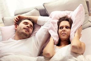 femme en colère au lit avec un homme qui ronfle photo