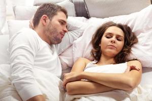 couple malheureux se disputant au lit photo